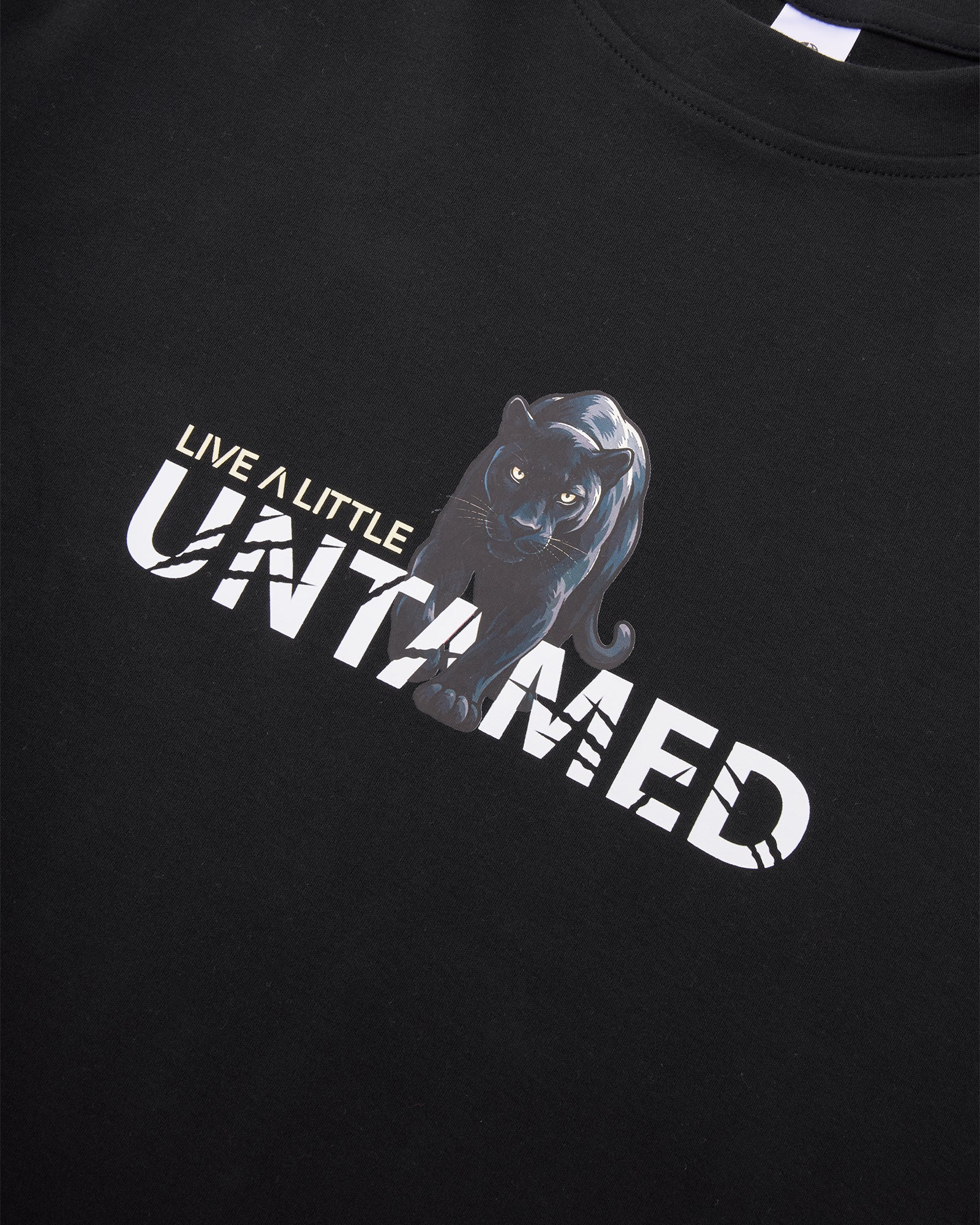 Untamed tee front graphic detail on black cotton fabric – close-up